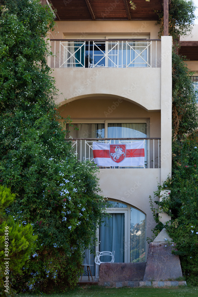 flag of belarus with the coat of arms on the balcony in Egypt. Patriotism. Beautiful building with green plants