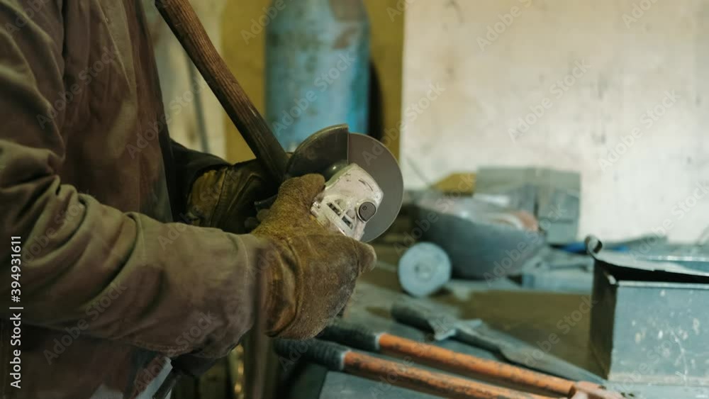 Man works circular saw. Sparks fly from hot metal. Man hard worked over the steel. Close-up slow motion shot in garage Man works circular saw. Sparks fly from hot metal. Man hard worked over the steel. Close-up slow motion shot in garage