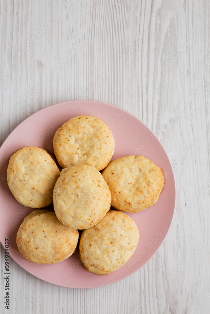 Homemade Flaky Buttermilk Biscuits on a pink plate on a white wooden surface, top view. Flat lay, overhead, from above. Copy space. Homemade Flaky Buttermilk Biscuits on a pink plate on a white wooden surface, top view. Flat lay, overhead, from above. Copy space.
