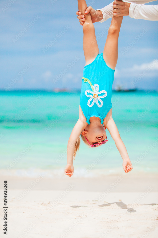 Little girl and happy dad having fun during beach vacation