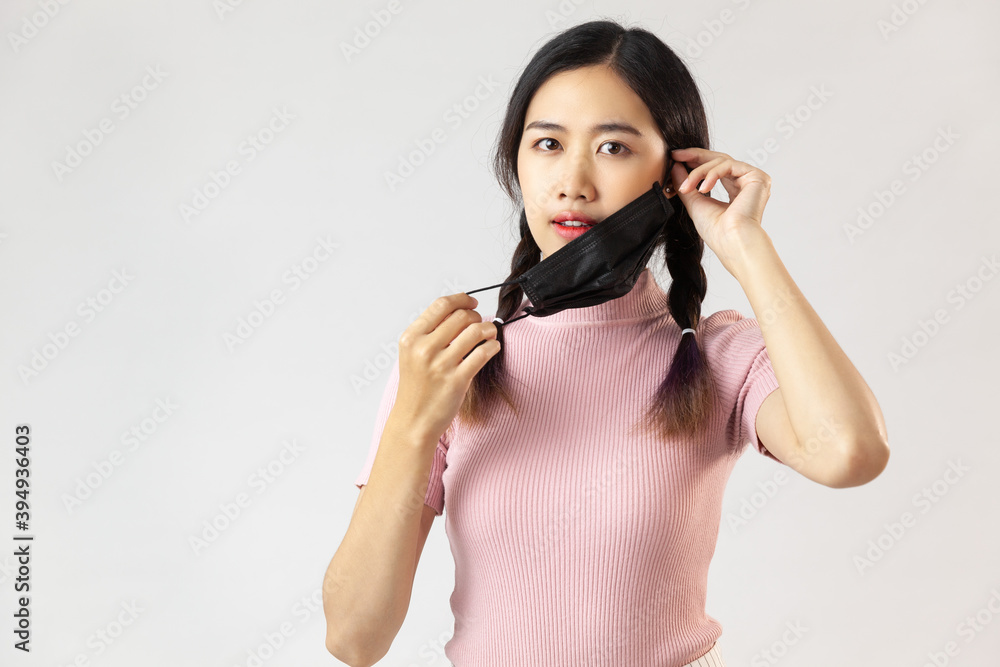 young asia woman removing mask from face with a protective face mask having breathing troubles during the COVID-19 pandemic young asia woman removing mask from face with a protective face mask having breathing troubles during the COVID-19 pandemic