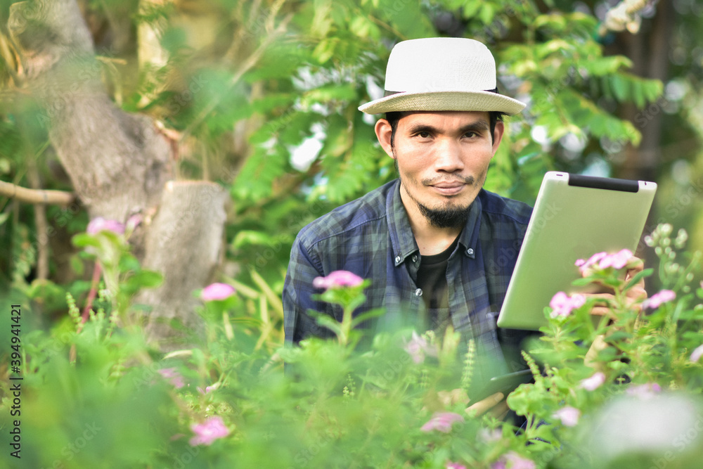 Asian man use tablet in farm are technology smart farmer Asian man use tablet in farm are technology smart farmer