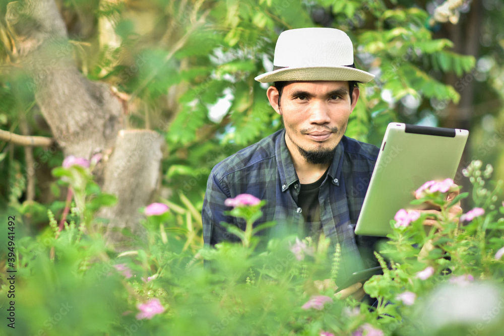 Asian man use tablet in farm are technology smart farmer Asian man use tablet in farm are technology smart farmer