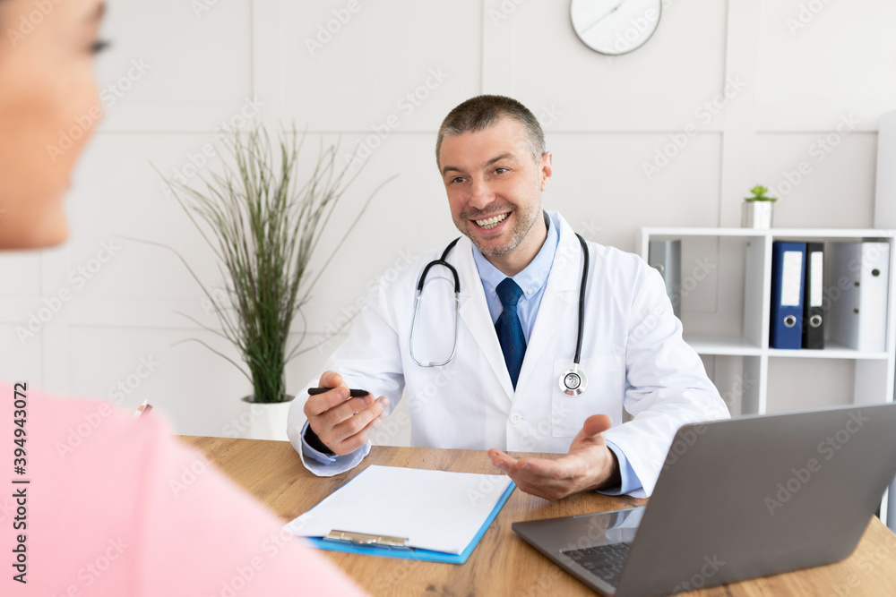 Smiling experienced doctor talking to his patient Smiling experienced doctor talking to his patient