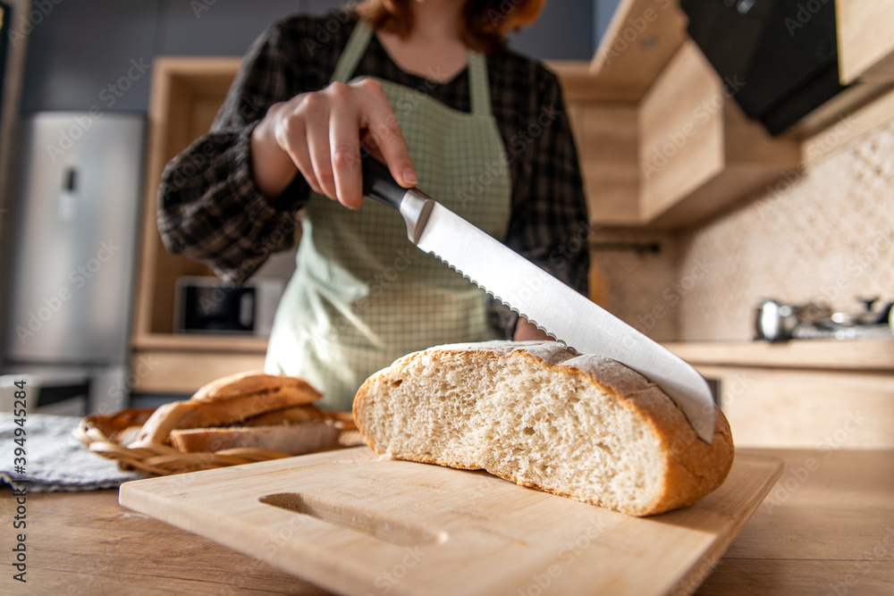 bread and knife. cutting bread on a cutting board. woman cut bread bread and knife. cutting bread on a cutting board. woman cut bread