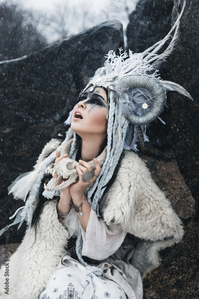 Φωτογραφία beautiful woman with black hair and fantasy make-up, in crown with horns and fea