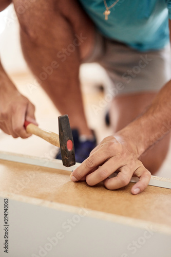 Handyman worker assembling furniture in new apartment, moving in and being hardworking.