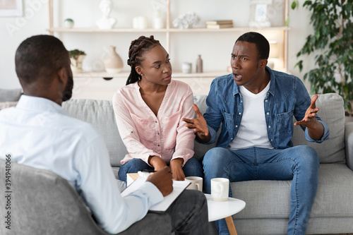 Young Black Spouses Having Relationship Problems, Sitting At Therapy Session With Counselor © Prostock-studio