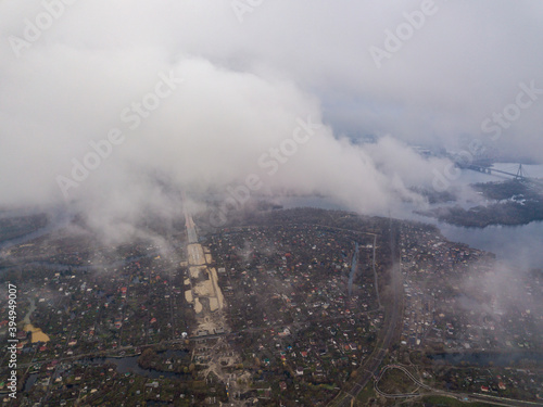 High aerial flight in the clouds over Kiev. An autumn cloudy morning  the Dnieper River is visible on the horizon.