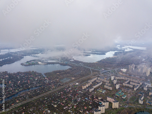 High aerial flight in the clouds over Kiev. An autumn cloudy morning  the Dnieper River is visible on the horizon.