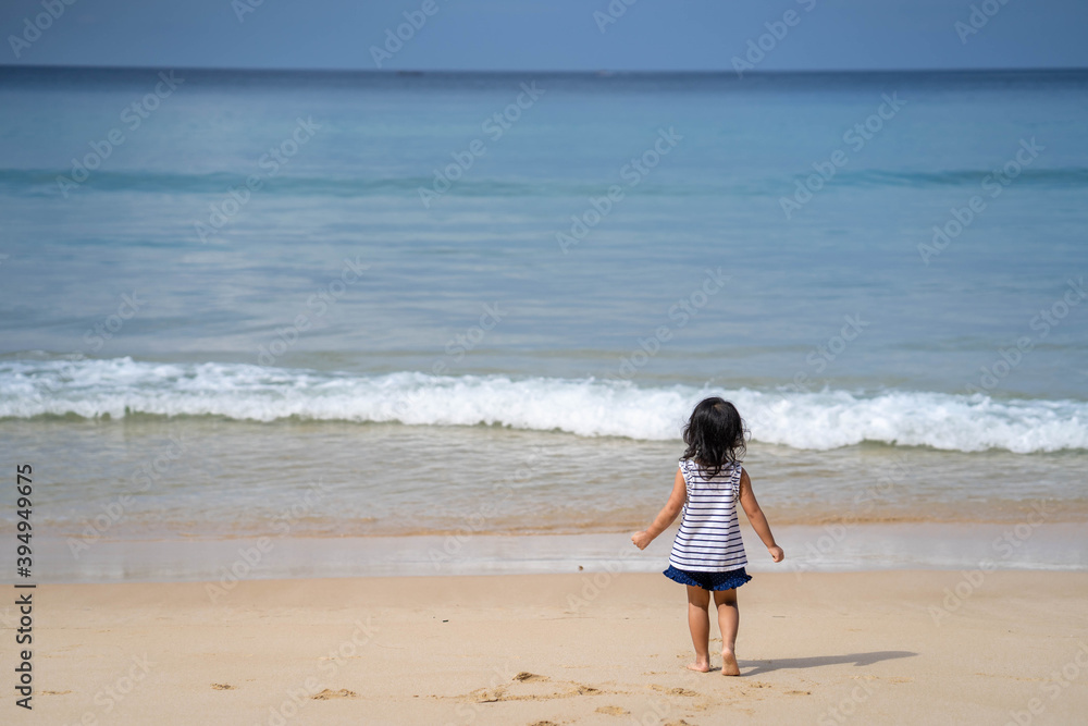 Active little girl playing at sea shore in Phang Nga Thailand.