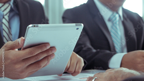 Businessmen wear a suit in a modern office using a tablet to study a projector, a businessman uses a tablet in a modern office.