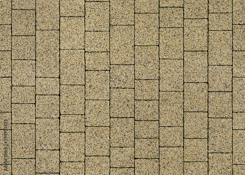 Seamless texture of street tiles.  Pattern of yellow paving slabs made of granite chips.