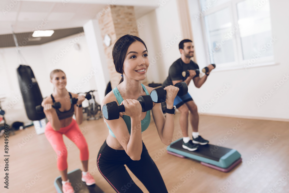 People do exercises with dumbbells together. People do exercises with dumbbells together.