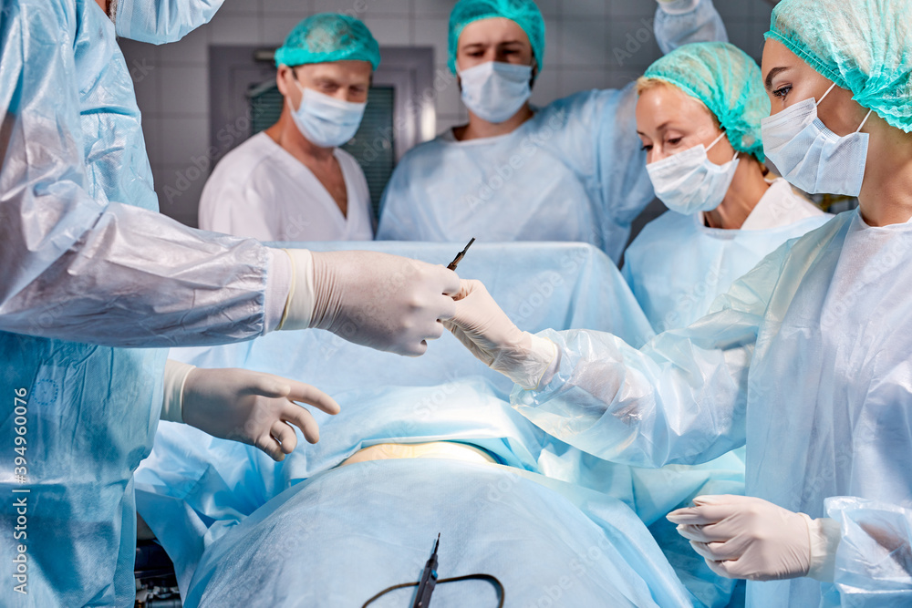 team of professional smart serious surgeons wearing medical uniform had difficult operation, in Technologically Advanced Hospital. operation on stomach, belly team of professional smart serious surgeons wearing medical uniform had difficult operation, in Technologically Advanced Hospital. operation on stomach, belly