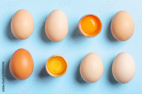 Raw chicken eggs on light blue background. Flat lay, copy space, top view.