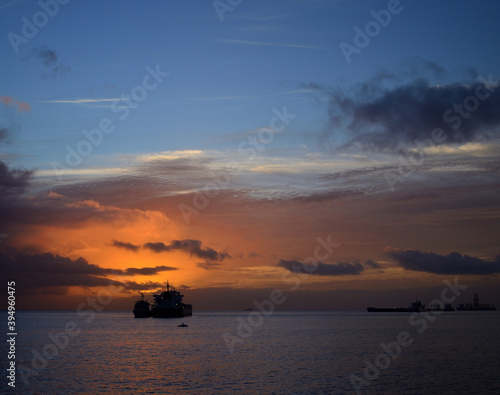 Sunrise from the sea with amazing sky, ships and low clouds