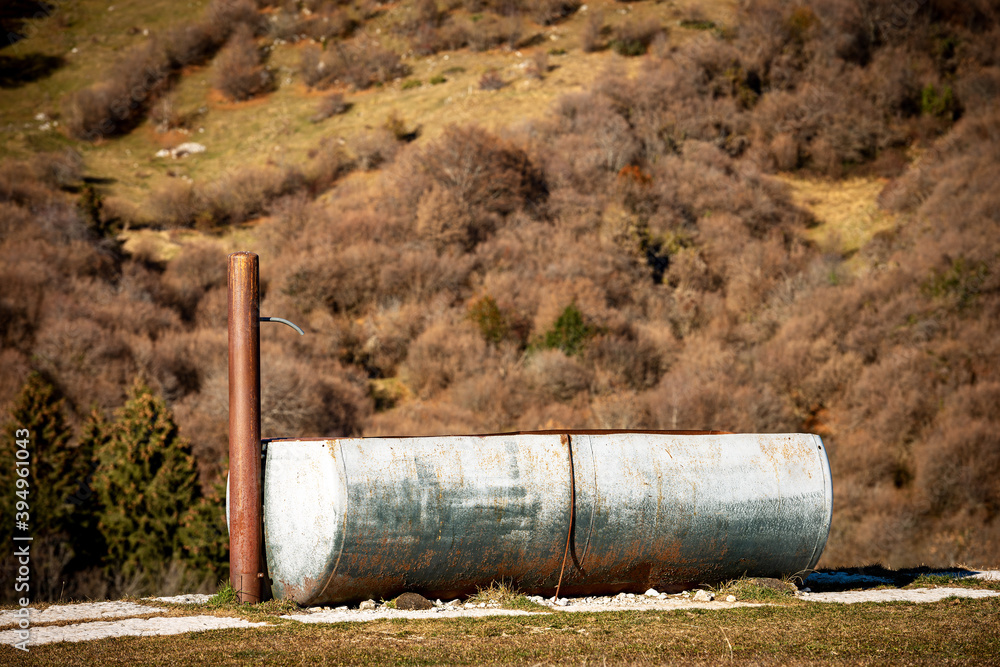 Closeup of a metal drinking trough for cows in mountain, Lessinia Plateau (Altopiano della Lessinia), Alps, Verona Province, Veneto, Italy, Europe. Closeup of a metal drinking trough for cows in mountain, Lessinia Plateau (Altopiano della Lessinia), Alps, Verona Province, Veneto, Italy, Europe.