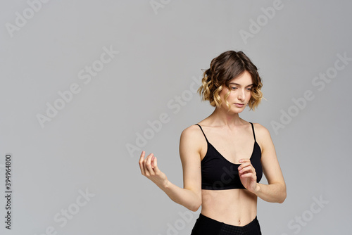 woman gesturing with her hands slim figure meditation sport gray background