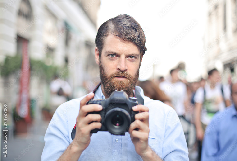 young man with digital camera in the street