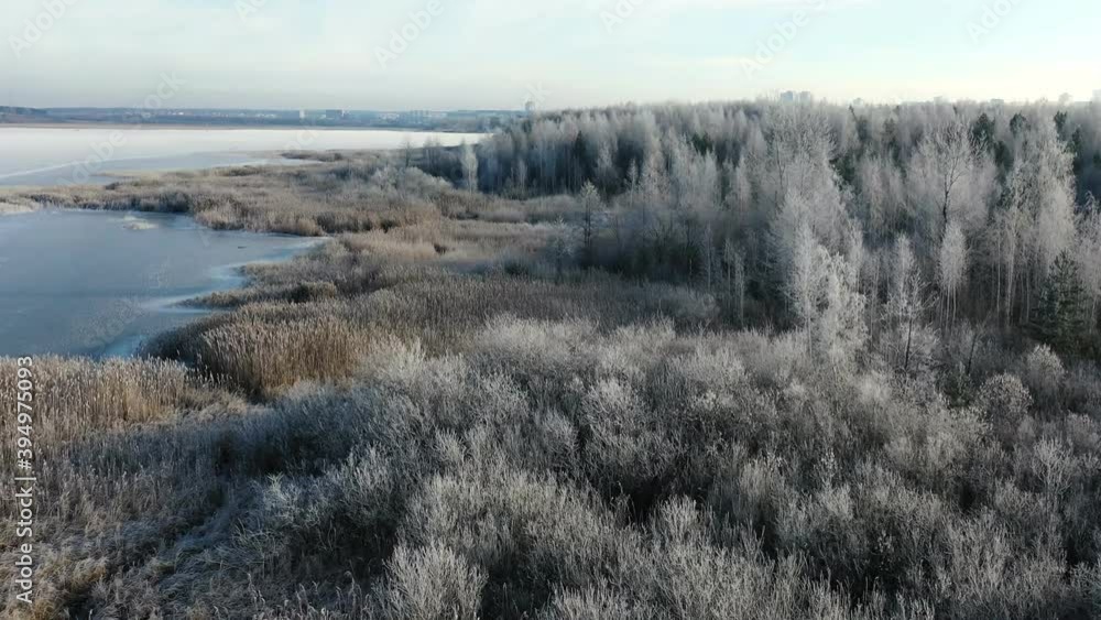 Copter flies over the beautiful bank of the frozen river