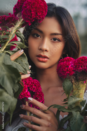 Obraz na płótnie closeup portrait of a beautiful young Thai woman surrounded by red flowers. Spring blossom w salonie