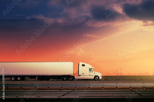 White truck driving on freeway road under red sunset sky landscape