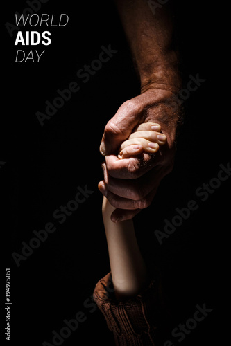 Child holds his father hand World AIDS Day Concept © alexxndr