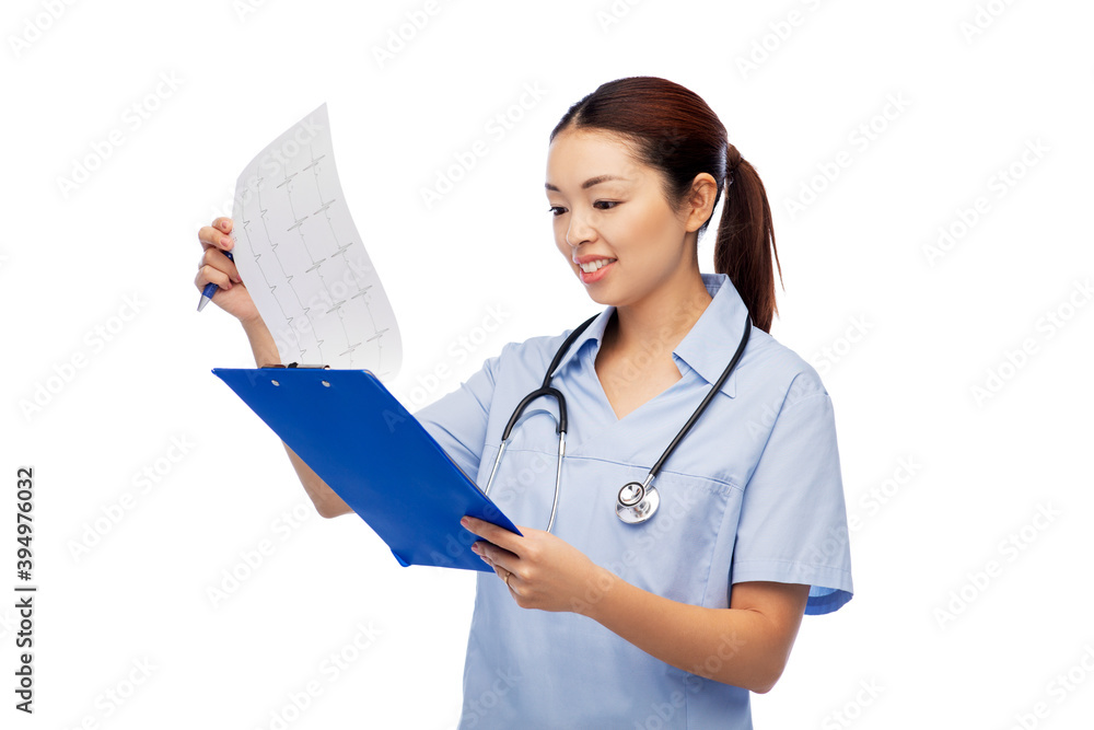 medicine, profession and healthcare concept - happy smiling asian female doctor or nurse in blue uniform with cardiogram on clipboard over white background medicine, profession and healthcare concept - happy smiling asian female doctor or nurse in blue uniform with cardiogram on clipboard over white background