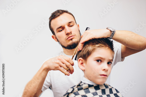 Hairdresser barbershop parihopher strechot small boy sitting on a chair
