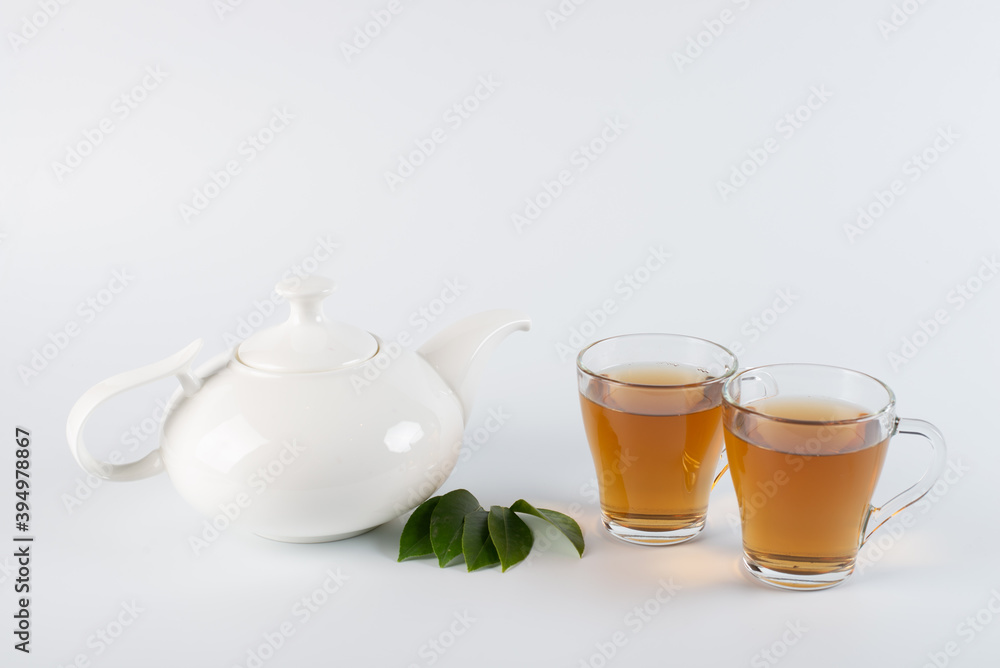 Green tea leaf and glass cup of black tea isolated on white background Green tea leaf and glass cup of black tea isolated on white background