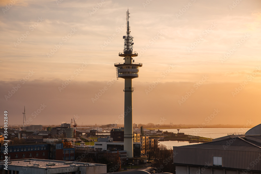 Radio tower in a harbor at sunset. Silhouette of the control tower in a port