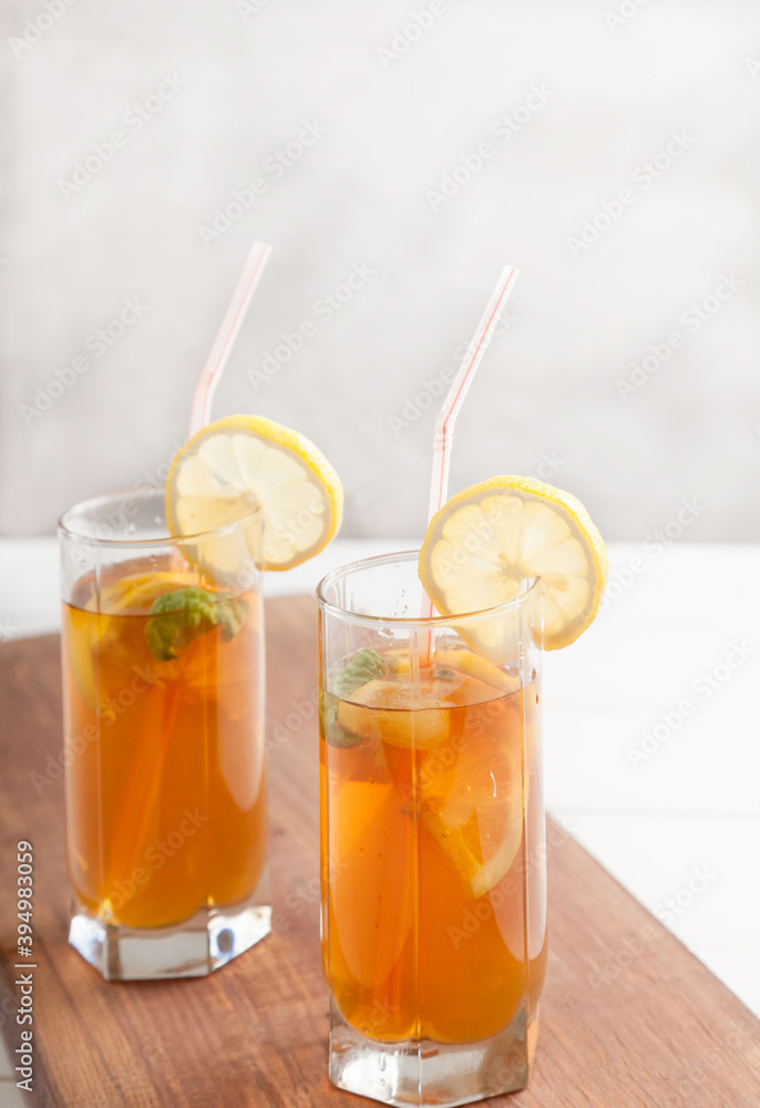 Two glasses with kombucha and lemon slices on a white table. Copy spaec. Vertical. Healthy food concept. Two glasses with kombucha and lemon slices on a white table. Copy spaec. Vertical. Healthy food concept.
