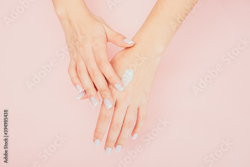 girl uses cream after bath. girl in a bathrobe hand cream