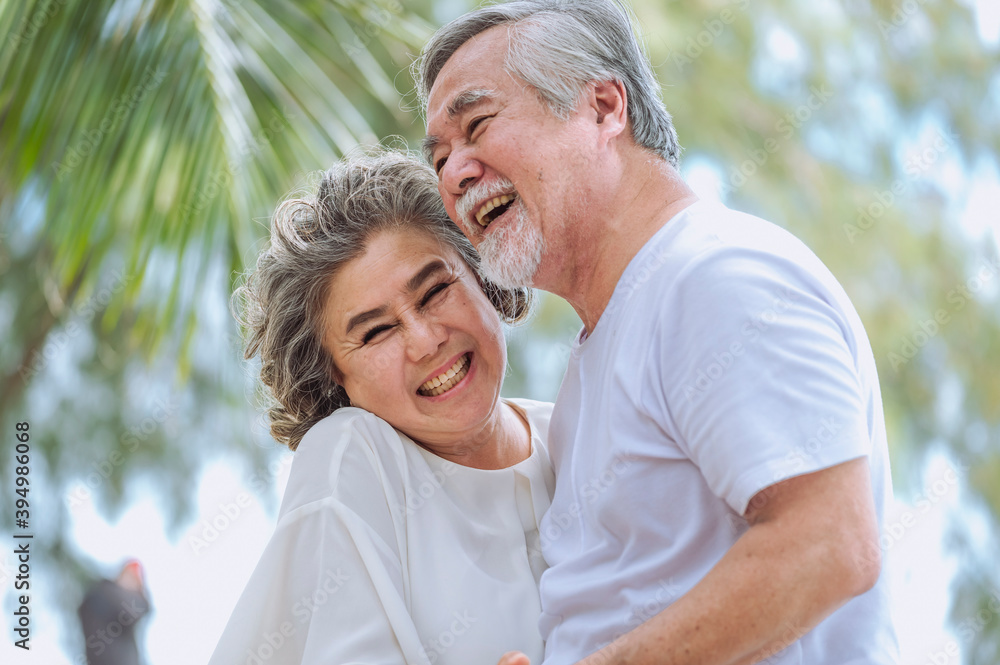 Happy asian senior retired couple, relax smiling elder man and woman enjoying with retired vacation at sea beach outdoor. Health care, Family outdoor lifestyle