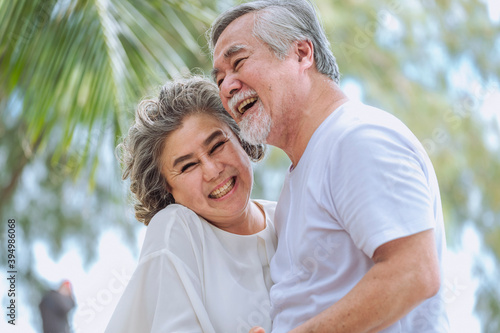Obraz na płótnie Happy asian senior retired couple, relax smiling elder man and woman enjoying with retired vacation at sea beach outdoor. Health care, Family outdoor lifestyle w salonie