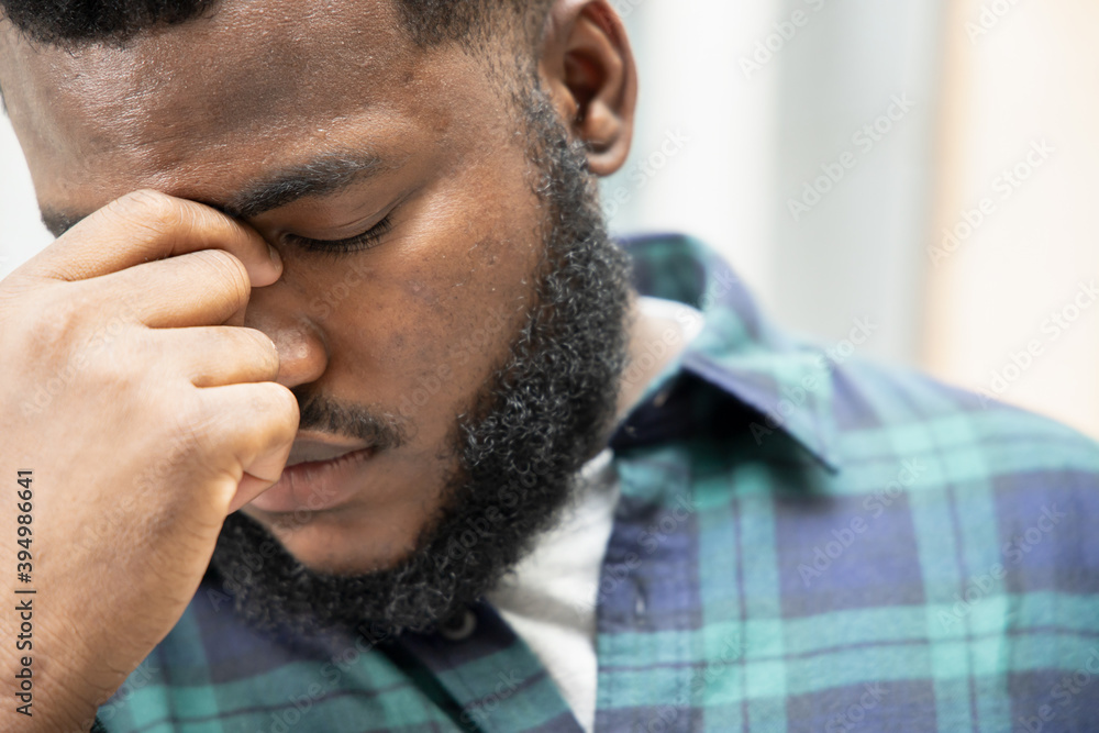 Obraz premium Sick black African man suffering from headache; health and sickness concept for vertigo, dizziness, stress, stroke, depression, burnout, Alzheimer disease, brain cancer, memory loss