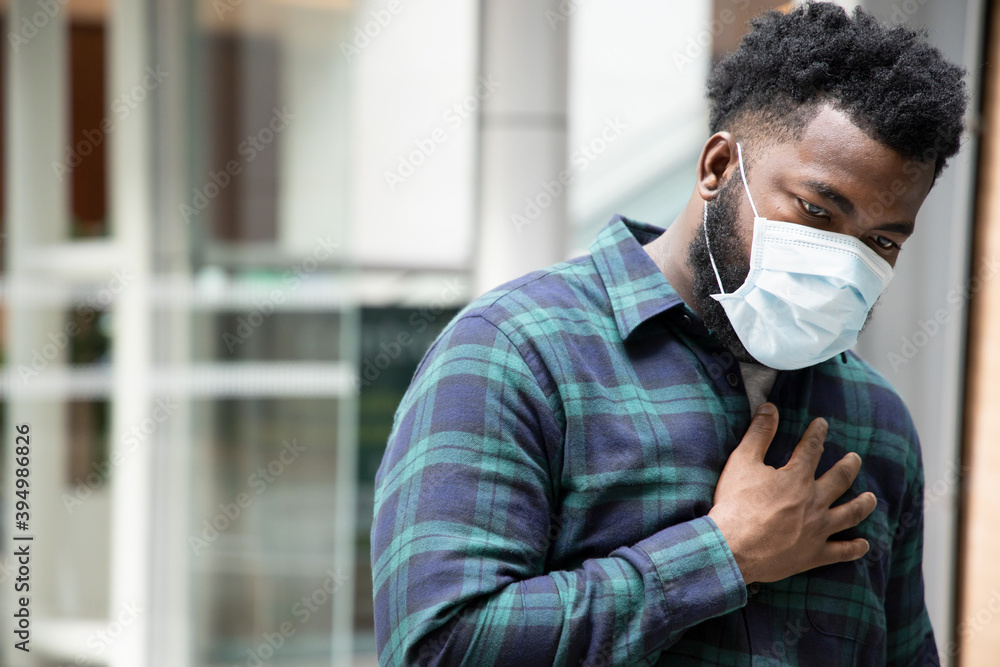 allergic sick black African man wearing face mask in public; concept of African man with allergy, pneumonia, sore throat, influenza, flu, cold, COVID-19 coronavirus, social distancing concept. allergic sick black African man wearing face mask in public; concept of African man with allergy, pneumonia, sore throat, influenza, flu, cold, COVID-19 coronavirus, social distancing concept.