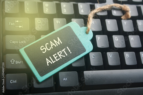 wooden tag written scam alert over keyboard button background