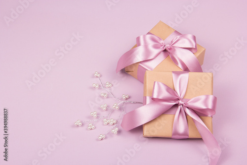 Gift boxes on a pink background with a pearl branch