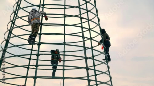 High-altitude installers assembling the frame of the Christmas tree