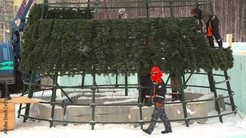 High-altitude installers assembling the frame of the Christmas tree