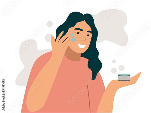 Woman smears cream face. Young woman use cosmetic to look beautiful.