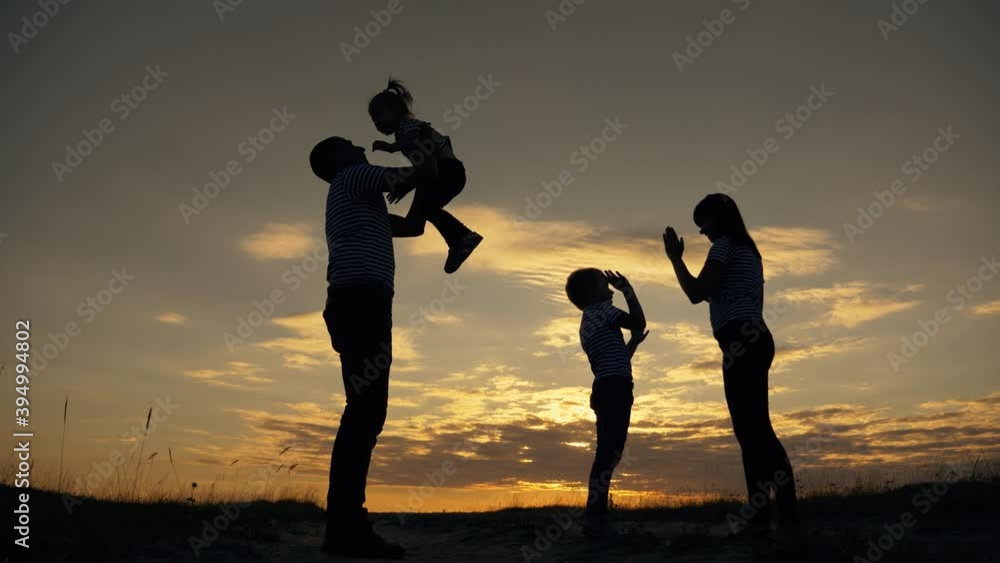 Happy family in the park. Silhouette of happy family in the park at sunset. Parents play with their children at sunset. Silhouette of group of people field. Happy family and vacation concept Happy family in the park. Silhouette of happy family in the park at sunset. Parents play with their children at sunset. Silhouette of group of people field. Happy family and vacation concept