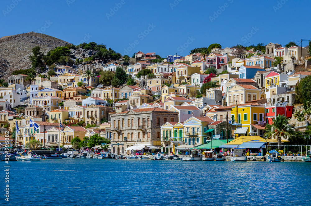 The charming and picturesque harbour if Simi is overlooked by rows of traditional houses each of them decorated with a Neoclassical façade and painted in bright pastel tones. 