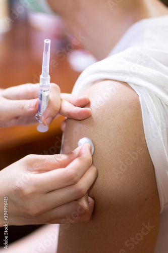 Doctor giving an injection to a male patient in the arm. Vaccine or flu shot in injection needle. Physician or nurse giving vaccination and immunity to virus, influenza or HPV, Covid 19, with syringe. © Avirut S.
