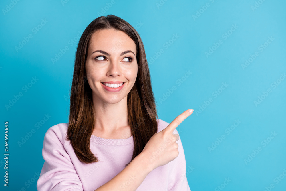 Close up photo pretty attractive lady good mood direct index finger look side empty space interesting proposition offer wear casual pink sweatshirt pullover isolated blue color background Close up photo pretty attractive lady good mood direct index finger look side empty space interesting proposition offer wear casual pink sweatshirt pullover isolated blue color background
