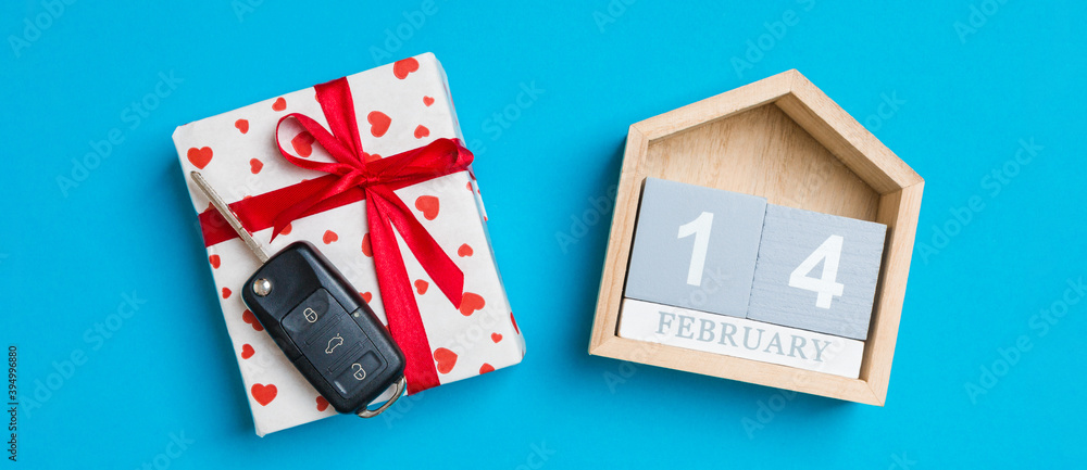 Top view of car key on a gift box with red hearts and festive calendar on colorful background. The fourteenth of february. Present for Valentine's Day concept Top view of car key on a gift box with red hearts and festive calendar on colorful background. The fourteenth of february. Present for Valentine's Day concept