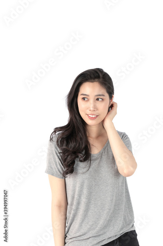 Happy cheerful young woman wearing gray t-shirt looking at camera with joyful and charming smile. Portrait of a pretty smiling woman posing isolated on a white background.