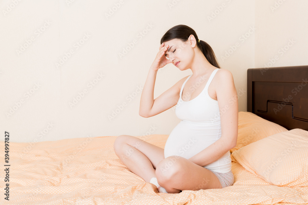 beautiful young pregnant woman lying in bed, top view. the girl suffers from the fact that her husband left her beautiful young pregnant woman lying in bed, top view. the girl suffers from the fact that her husband left her